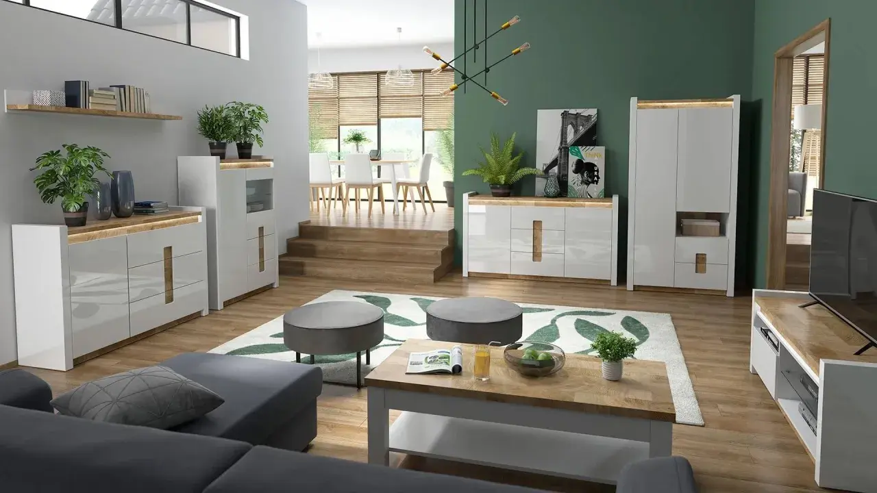 Nowoczesny salon z szarą kanapą, drewnianym stolikiem i komodami. Jedna ściana innego koloru, zielona, dodaje głębi.