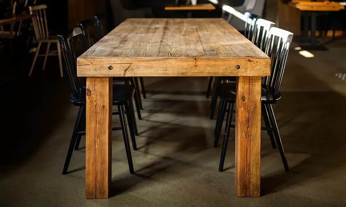 Drewniany stół i krzesła, jak po czyszczeniu starych mebli z brudu. Wnętrze restauracji.