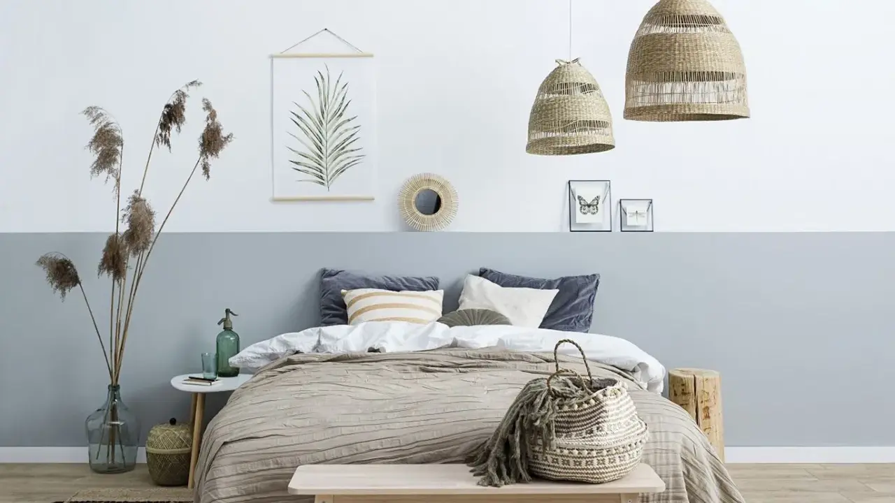 Przytulna sypialnia w stylu boho. Pokój dwukolorowy z łóżkiem, plecionymi lampami i ozdobami z naturalnych materiałów.