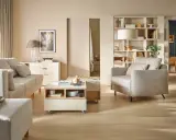 Jasny salon z sofą, fotelem i stolikiem kawowym. Inspiracja, jak ustawić meble w salonie, by stworzyć przytulną przestrzeń.