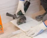 Ręczne cięcie płytek kątówką to jeden z domowych sposobów na precyzyjne dopasowanie materiału. Poziomica pomaga w dokładności.