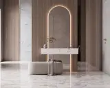 Elegancka ściana z luster w przedpokoju, z łukowym podświetleniem, marmurowym blatem i pufą.