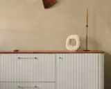 Nowoczesna kuchnia z białymi, ryflowanymi frontami IKEA, czarnym kranem i dekoracjami na blacie.