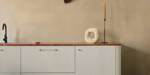 Nowoczesna kuchnia z białymi, ryflowanymi frontami IKEA, czarnym kranem i dekoracjami na blacie.