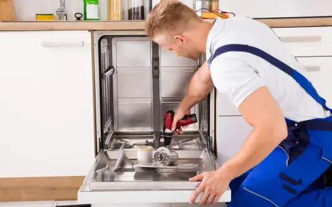 Fachowiec montuje front do zmywarki Ikea, używając wiertarko-wkrętarki.