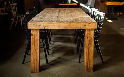 Drewniany stół i krzesła, jak po czyszczeniu starych mebli z brudu. Wnętrze restauracji.