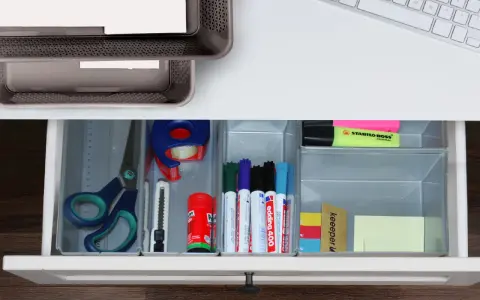 Inspiracje na organizację biurka: nożyczki, taśma, markery, linijka i karteczki w szufladzie.