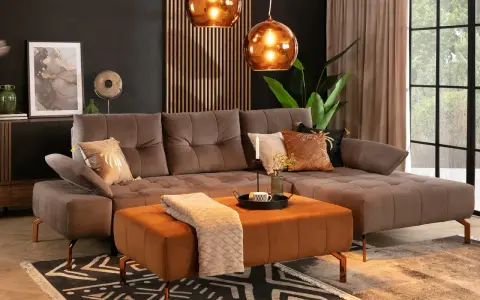 Elegancki salon z brązową kanapą w kolorze taupe jaki to kolor. Miękki dywan i pomarańczowa pufa dodają ciepła.