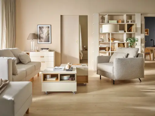 Jasny salon z sofą, fotelem i stolikiem kawowym. Inspiracja, jak ustawić meble w salonie, by stworzyć przytulną przestrzeń.