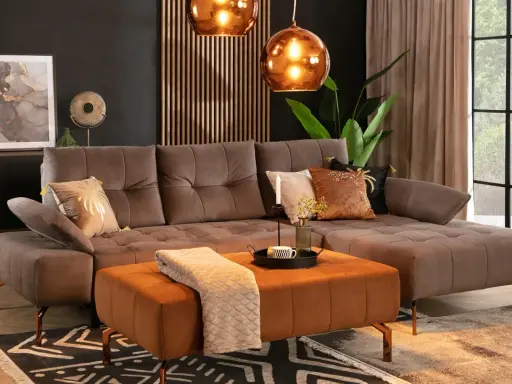 Elegancki salon z brązową kanapą w kolorze taupe jaki to kolor. Miękki dywan i pomarańczowa pufa dodają ciepła.