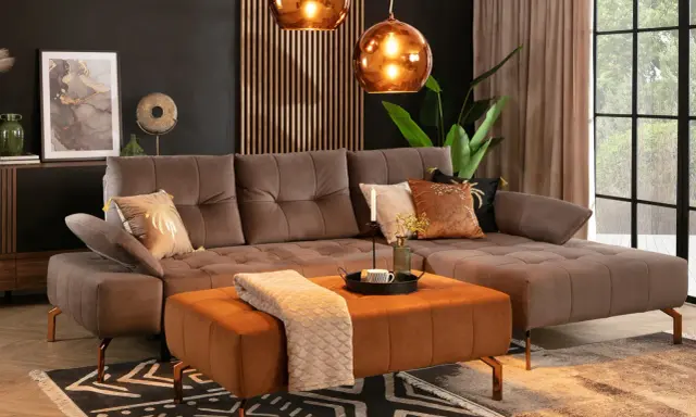 Elegancki salon z brązową kanapą w kolorze taupe jaki to kolor. Miękki dywan i pomarańczowa pufa dodają ciepła.