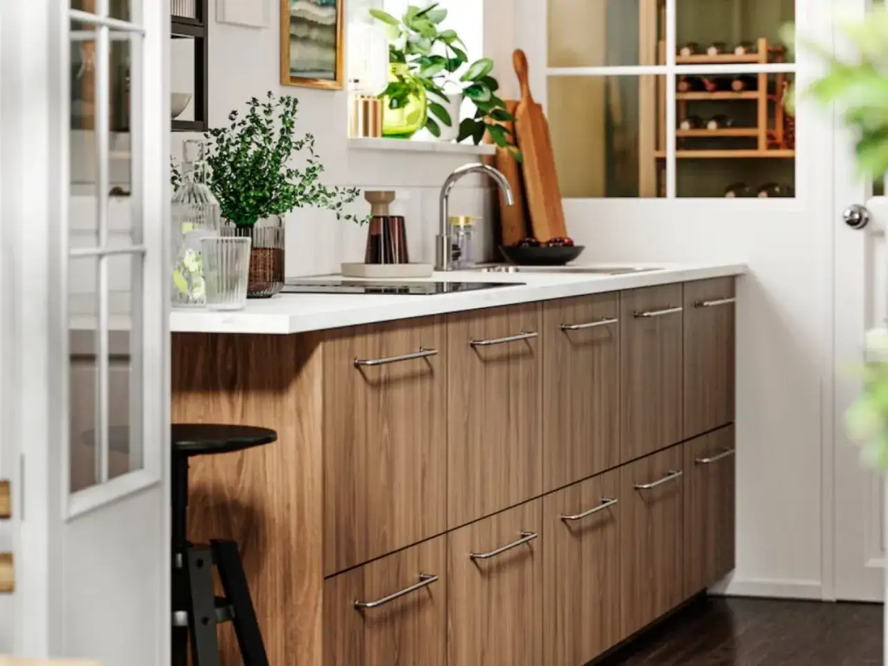 Nowoczesna kuchnia z drewnianymi frontami IKEA, białym blatem i stylowymi uchwytami.