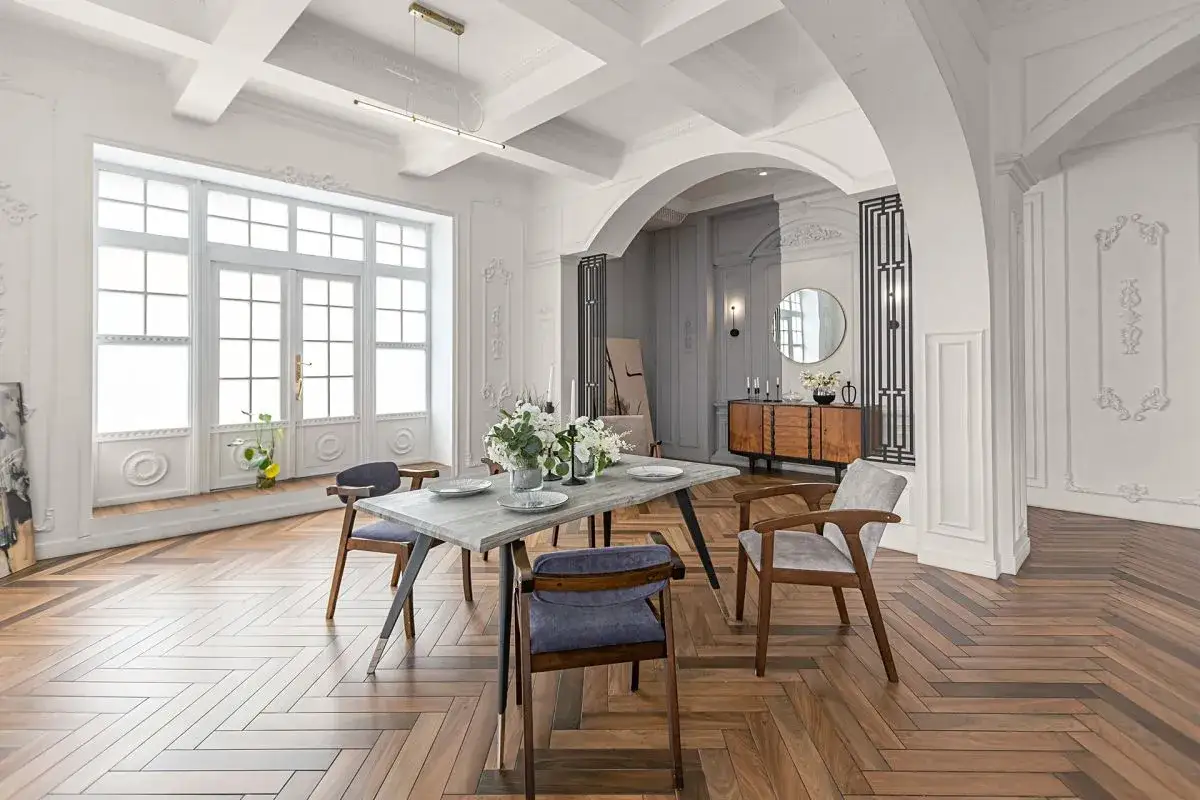 Elegancki salon z jadalnią, gdzie łuk w salonie inspiracje tworzy przestrzeń. Drewniana podłoga w jodełkę, st&oacute;ł z krzesłami i komoda.